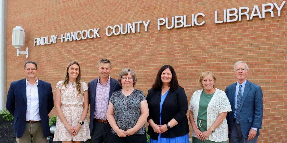 Board members standing in the front of the building