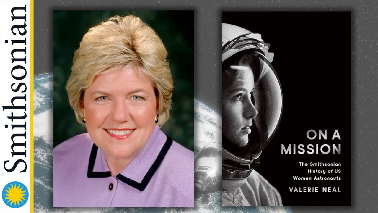 author in pink suit with black trim beside book cover showing female astronaut