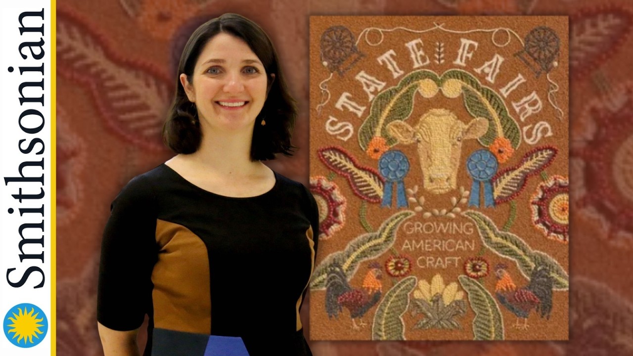 female with short dark hair in a black dress beside a quilt