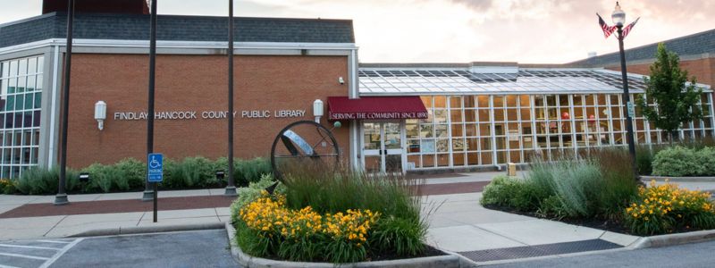 front of library with yellow flowers growing