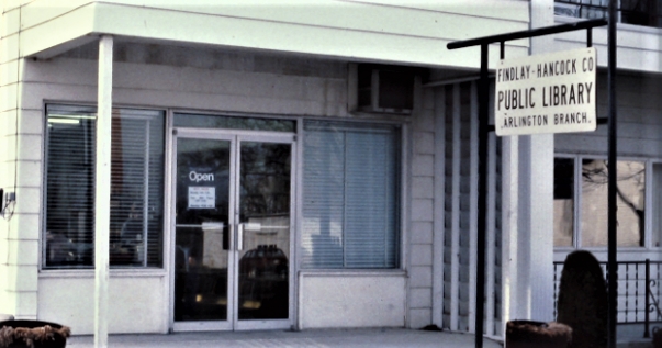 library building in Arlington with white siding and open sign in the window