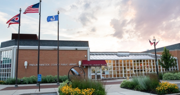 Current library building with yellow flowers blooming in flowerbeds