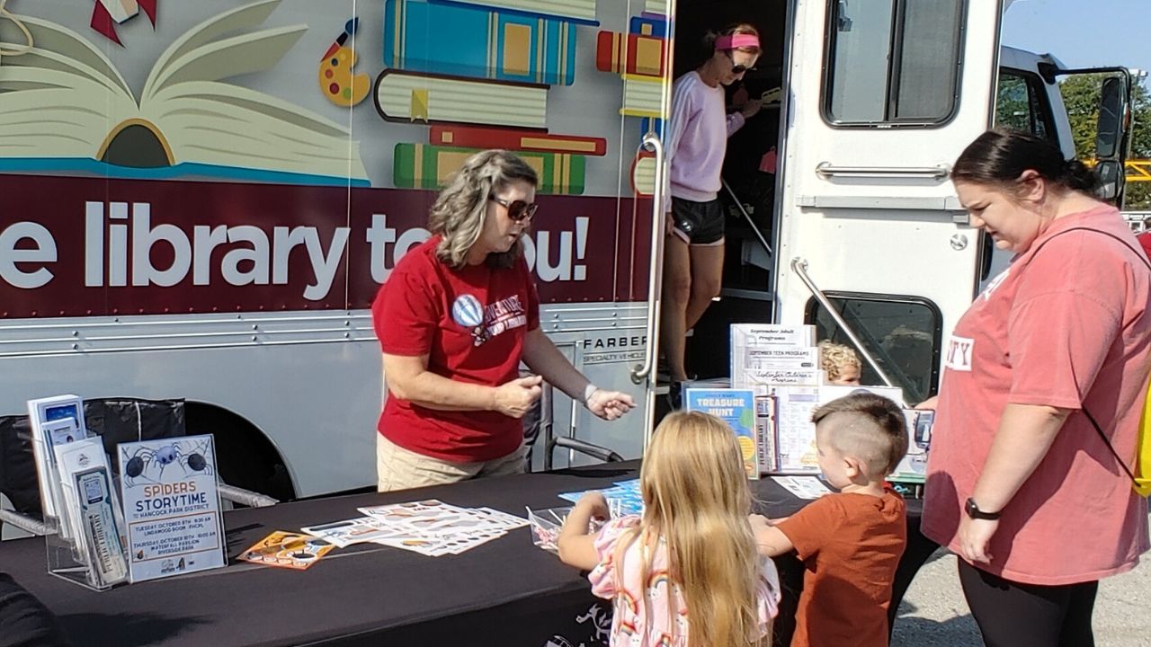 lisa at event talking to children with Bookmobile in the background