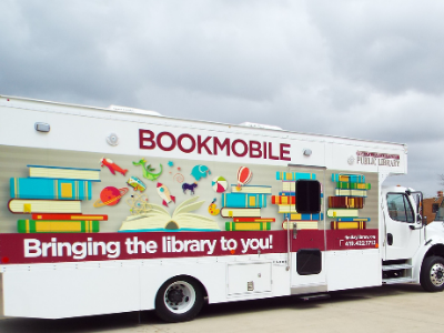 photo of colorful new bookmobile with red, blue yellow green and orange graphics