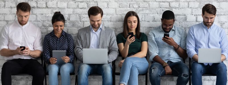 people sitting in chairs all using different devices